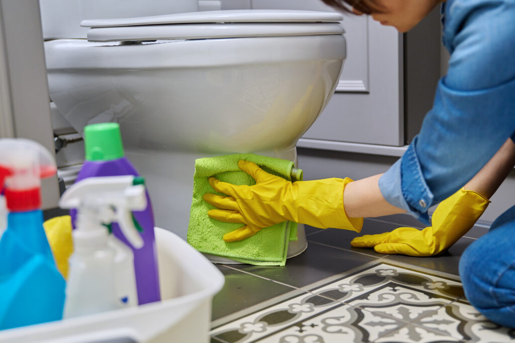 woman cleaning toilet in bathroom with gloves 2026 01 06 09 45 42 utc